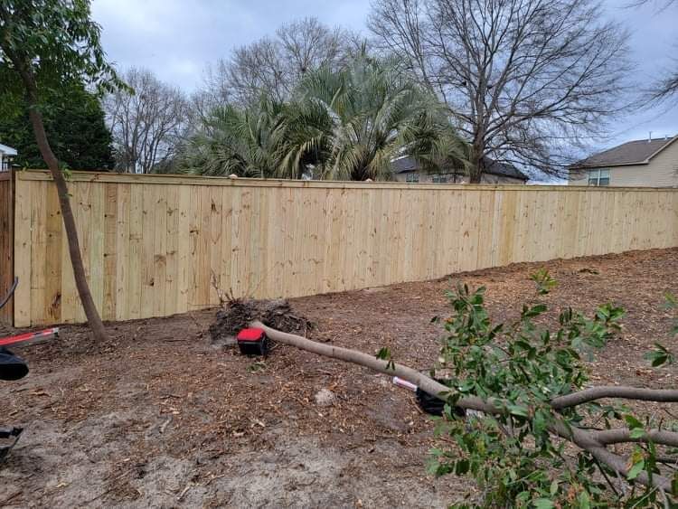 A wooden fence is sitting in the middle of a dirt field.