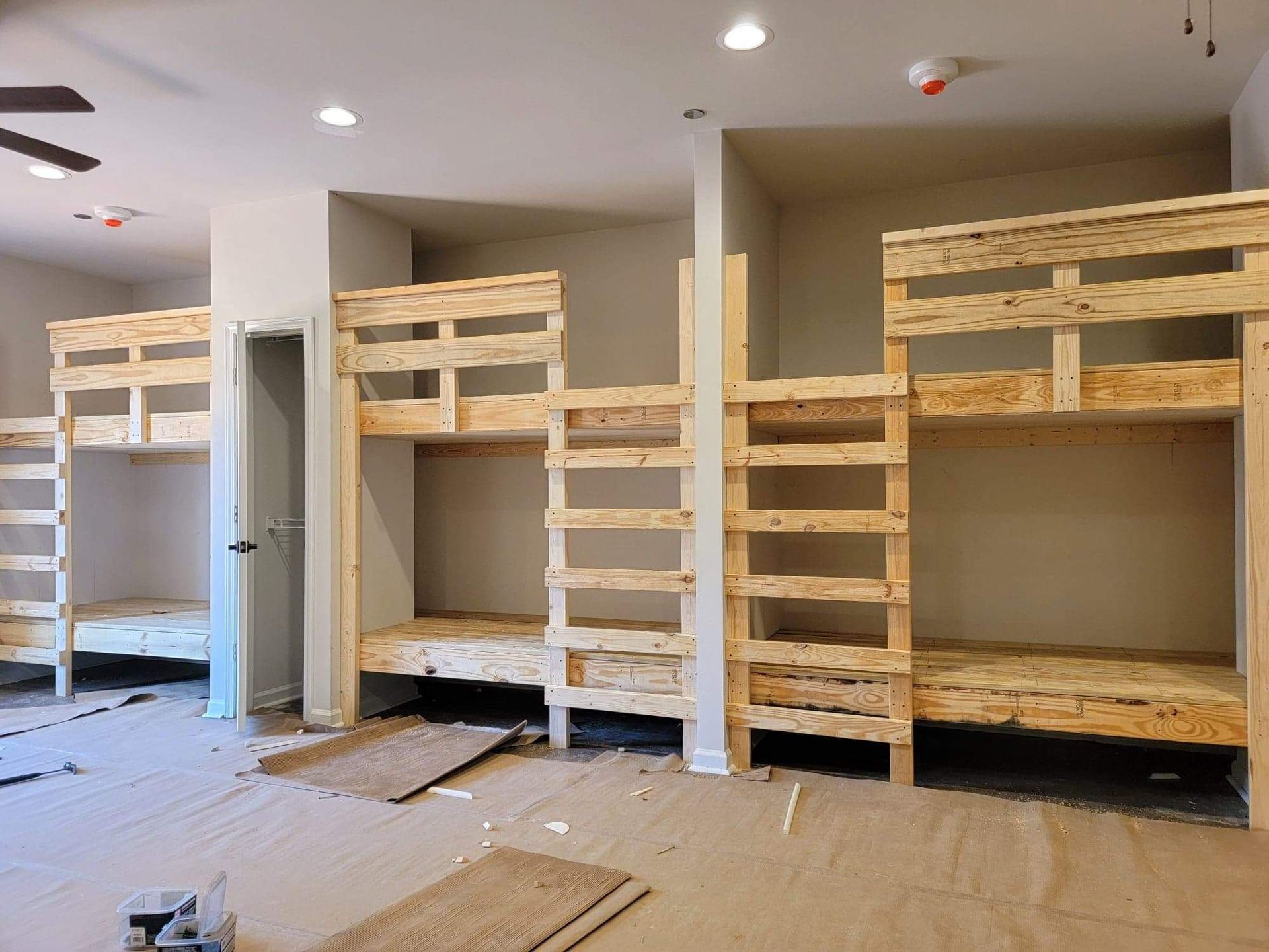 A room with bunk beds and a ceiling fan.