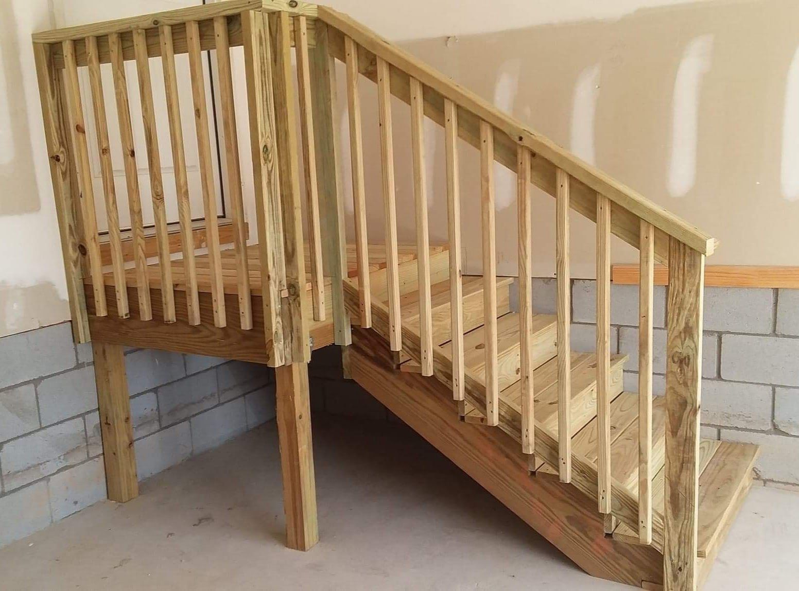 A wooden staircase with a railing in a room