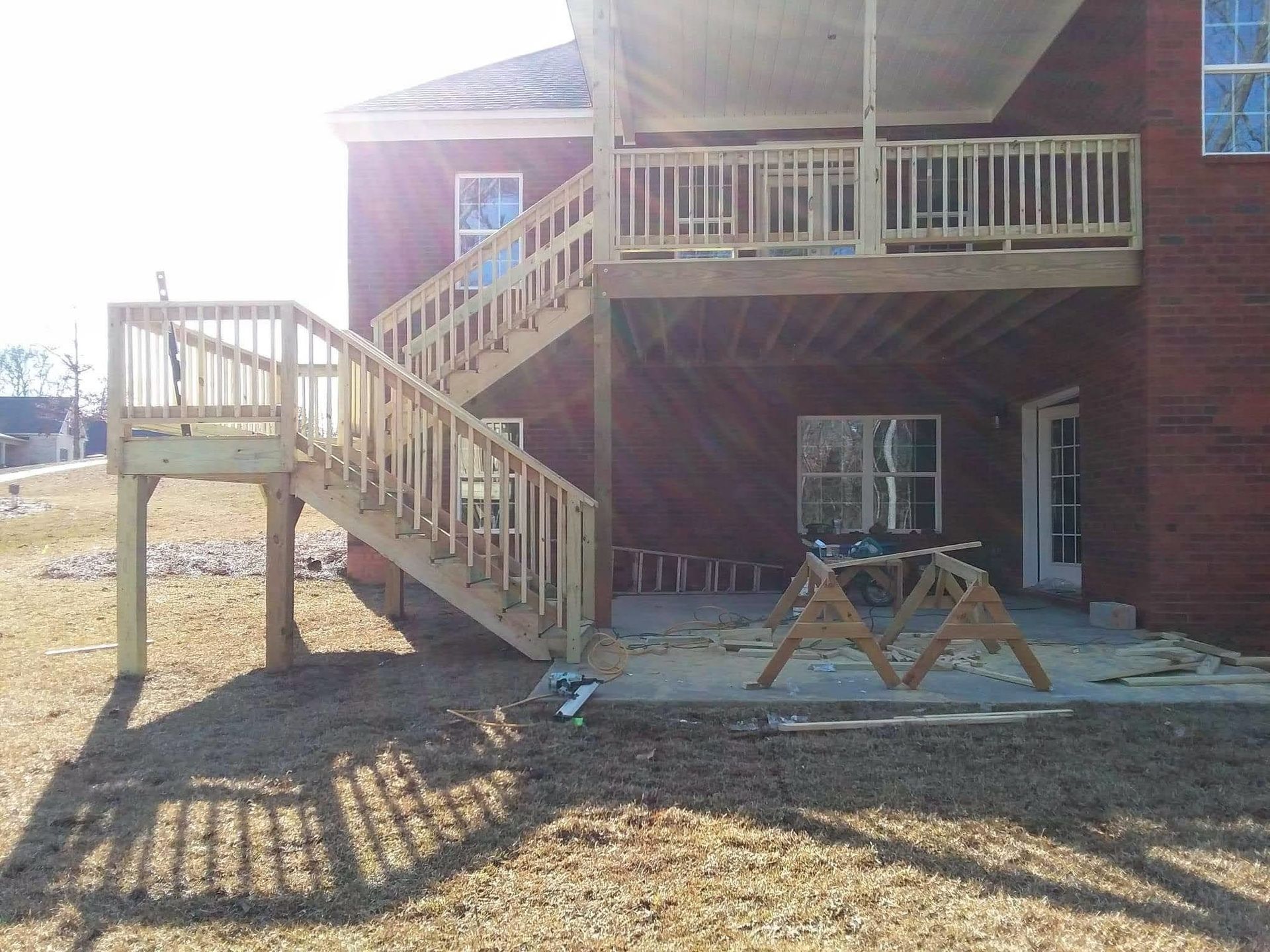 A brick house with a wooden deck and stairs