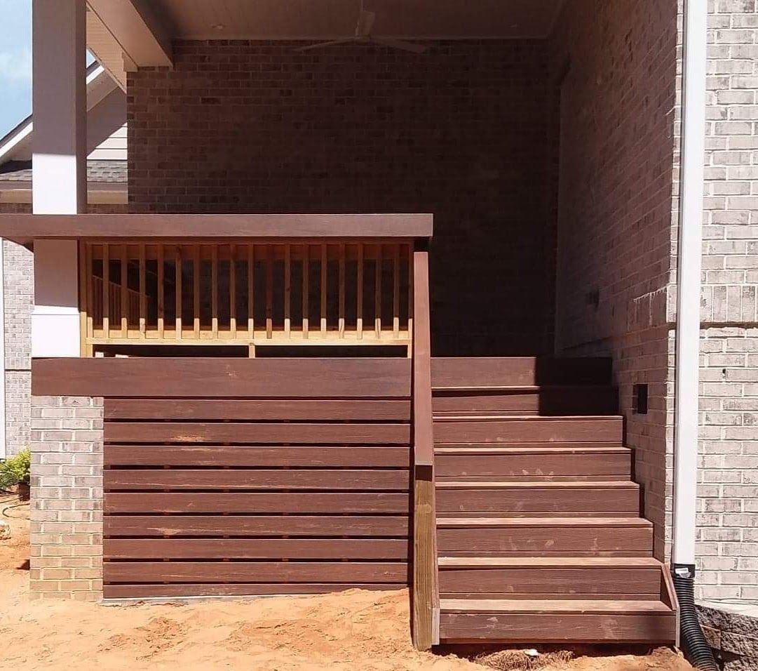 A brick house with a wooden deck and stairs