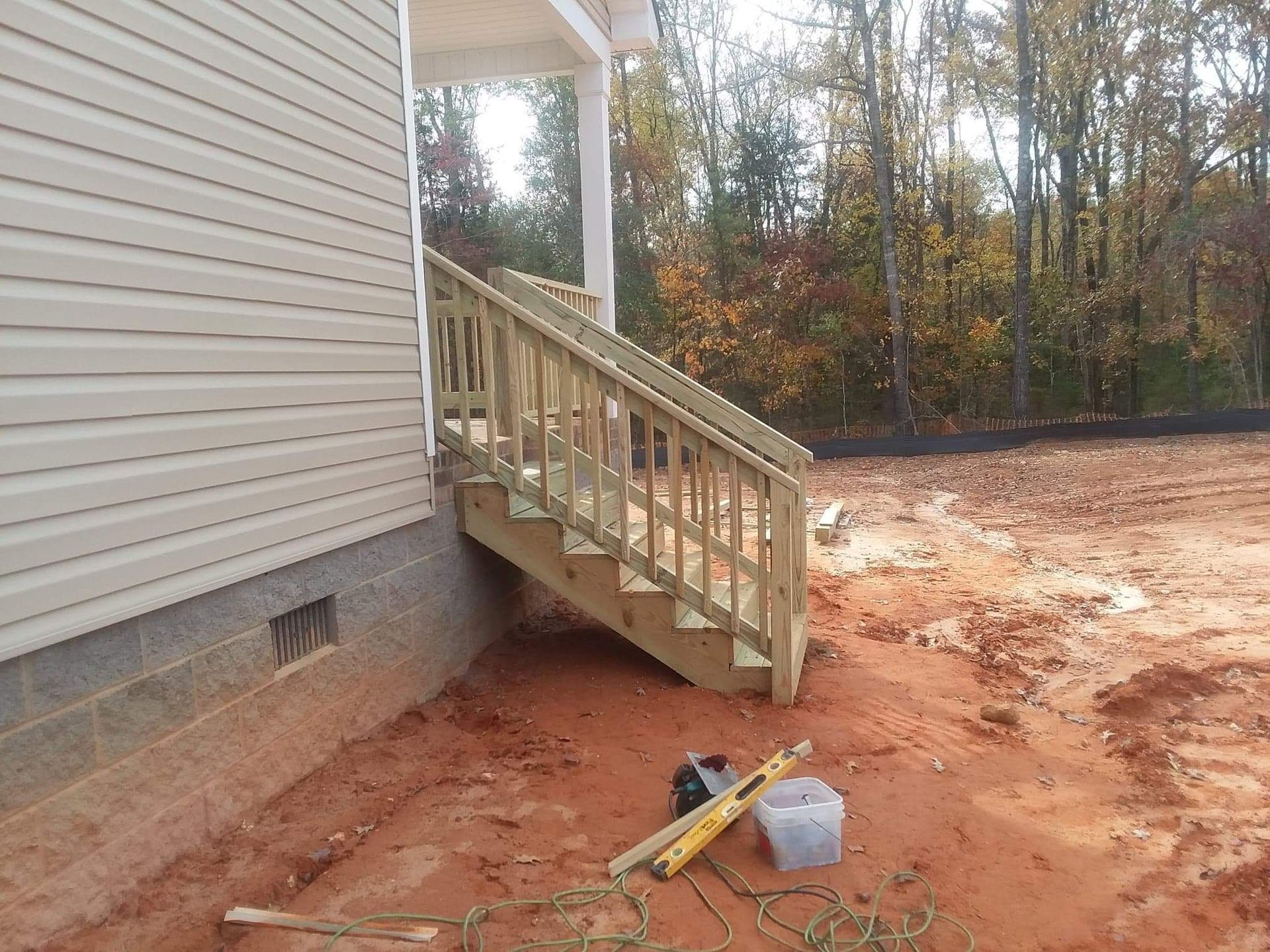 A wooden staircase is being built on the side of a house