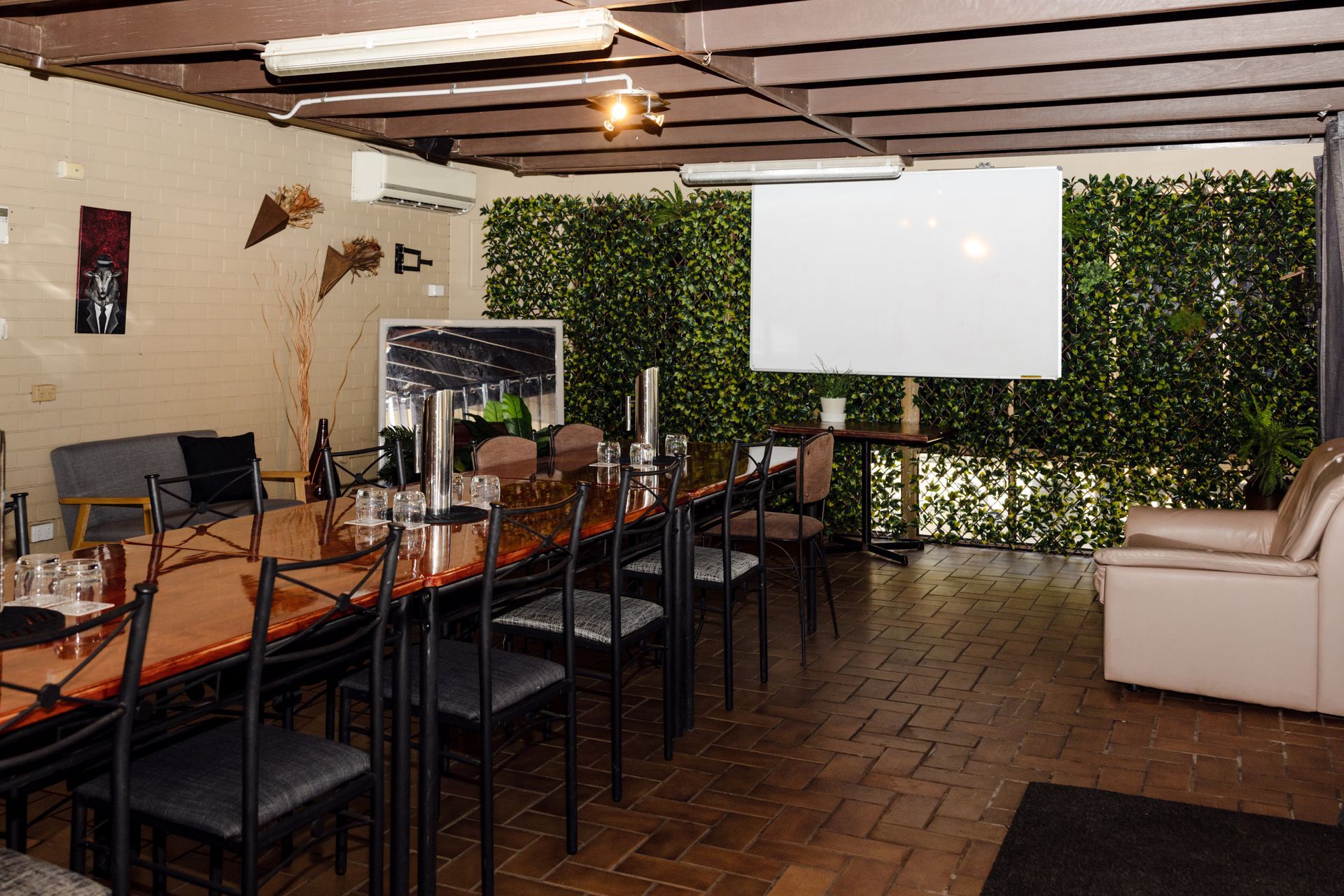 A room with a long table and chairs and a projector screen