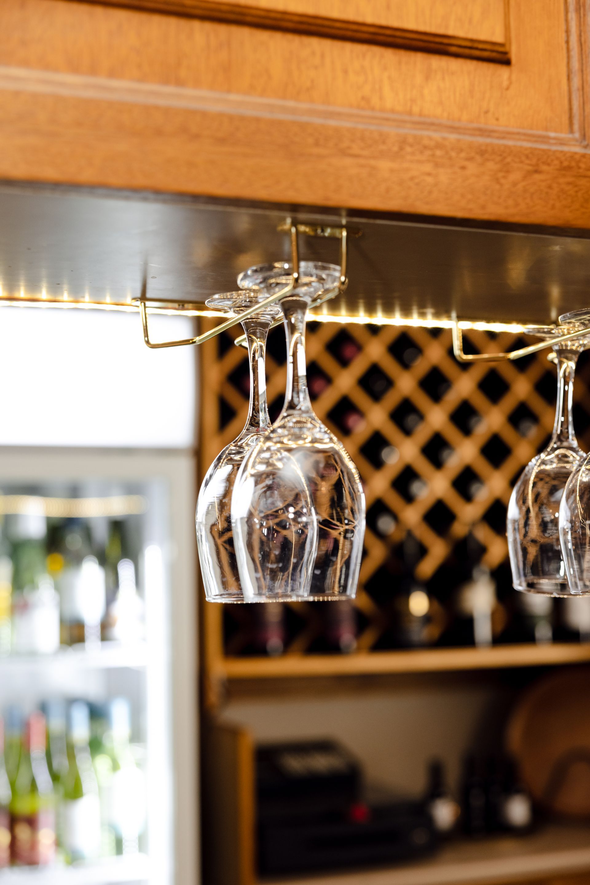 A wine rack with wine glasses hanging from it