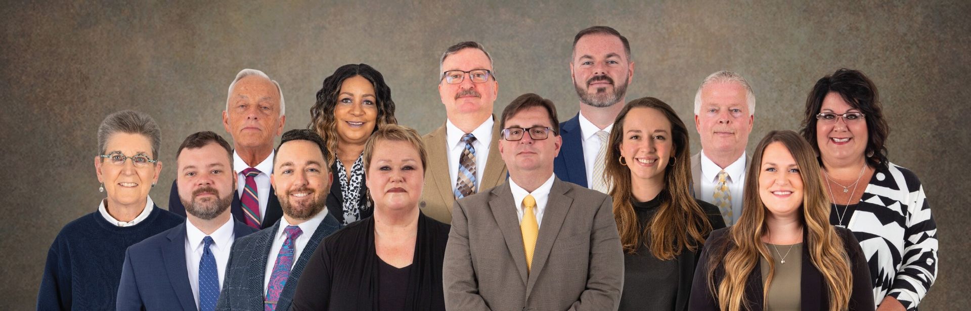 A group of people in suits and ties are posing for a picture.