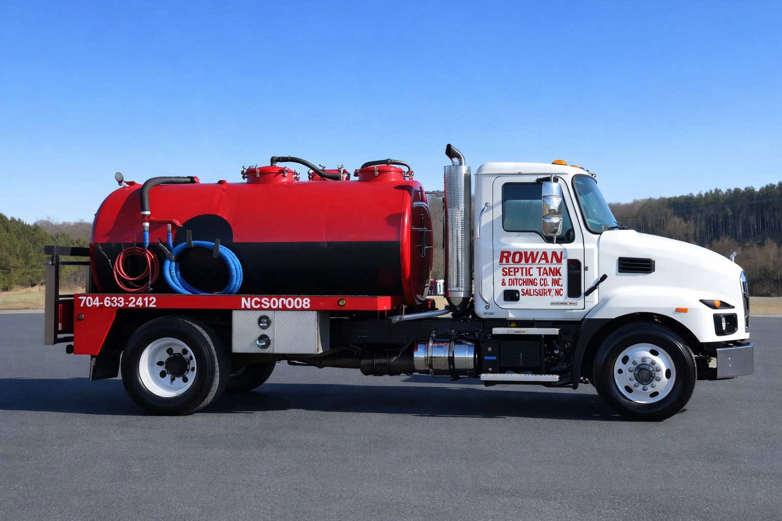 A man is pumping a hose into a septic tank.