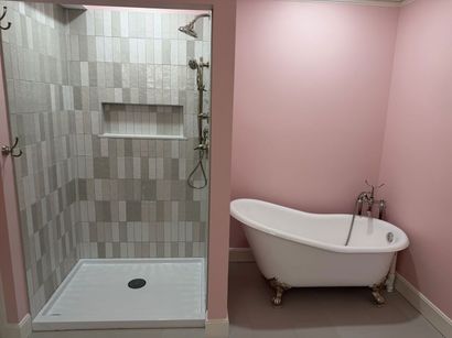 Pink bathroom with a walk-in shower and a white clawfoot bathtub Pink bathroom with a walk-in shower and a white clawfoot bathtub