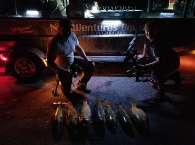 Bowfishing Adventures — Two Bowfishermen with their Catch in Low Light in Lancaster County, PA