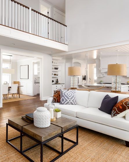 A living room with a white couch and two coffee tables.