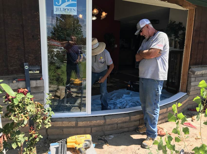 a custom window by Sun Glass is being installed by Sun Glass employee