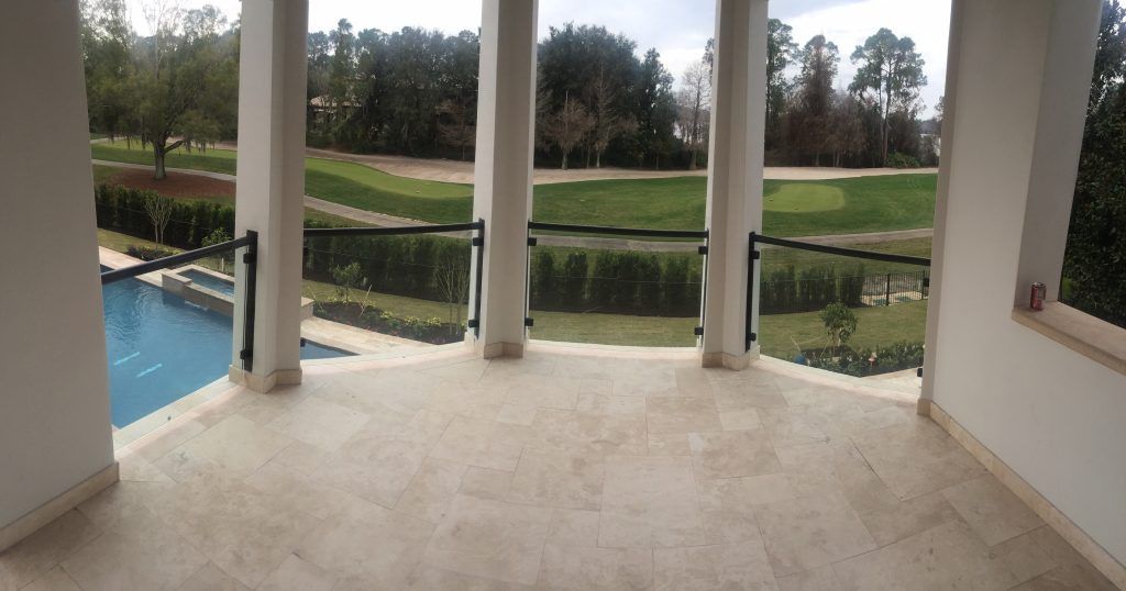 patio with custom glass rails from Sun Glass, with a view of the golf course