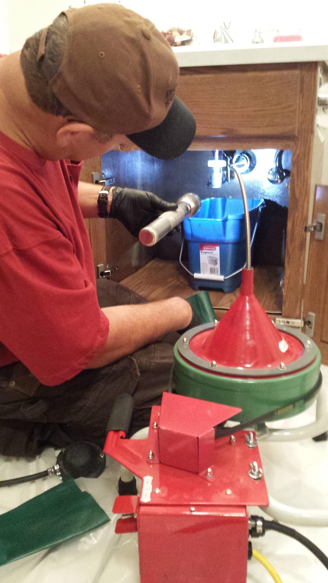 A man is sitting on the floor working on a machine.