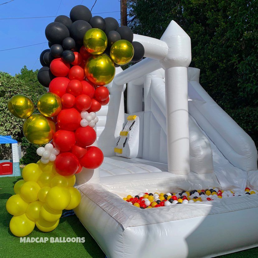 Large organic balloon garland attached to bouncy house