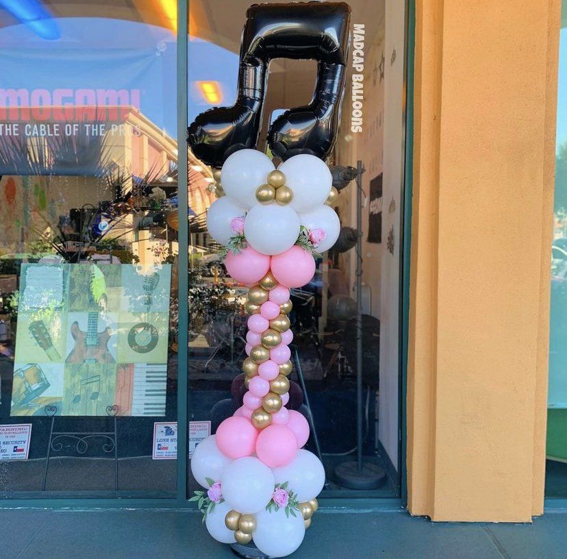 Pink, white, and black music note balloon column