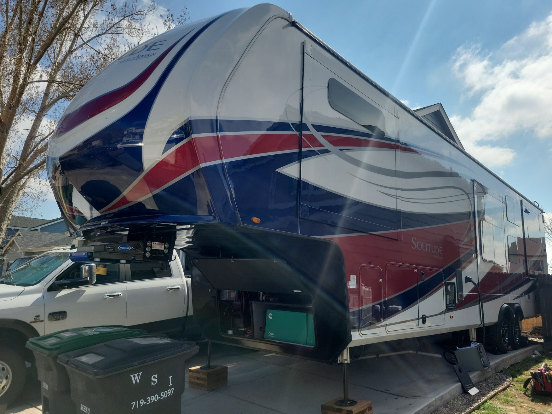 A red , white and blue rv is parked in a parking lot.