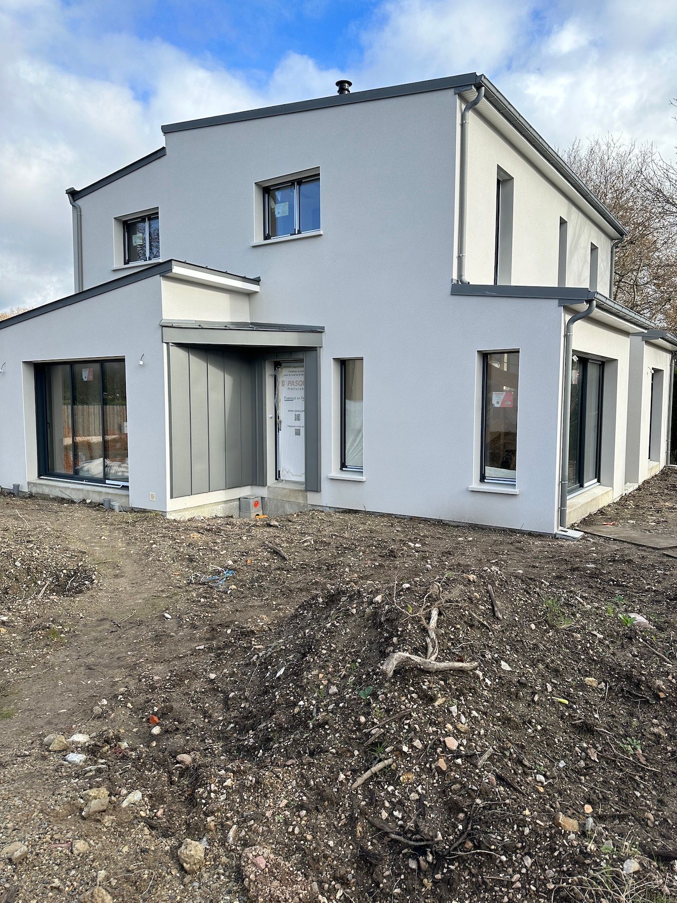 Une maison blanche est assise au sommet d'une colline de terre.