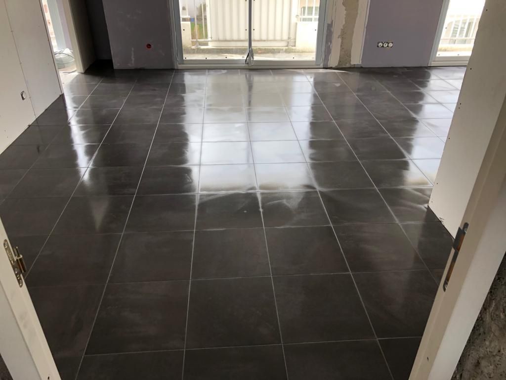 Une pièce avec un sol carrelé et une porte coulissante en verre.