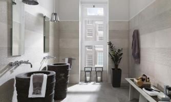 Une salle de bain avec deux lavabos et un banc.