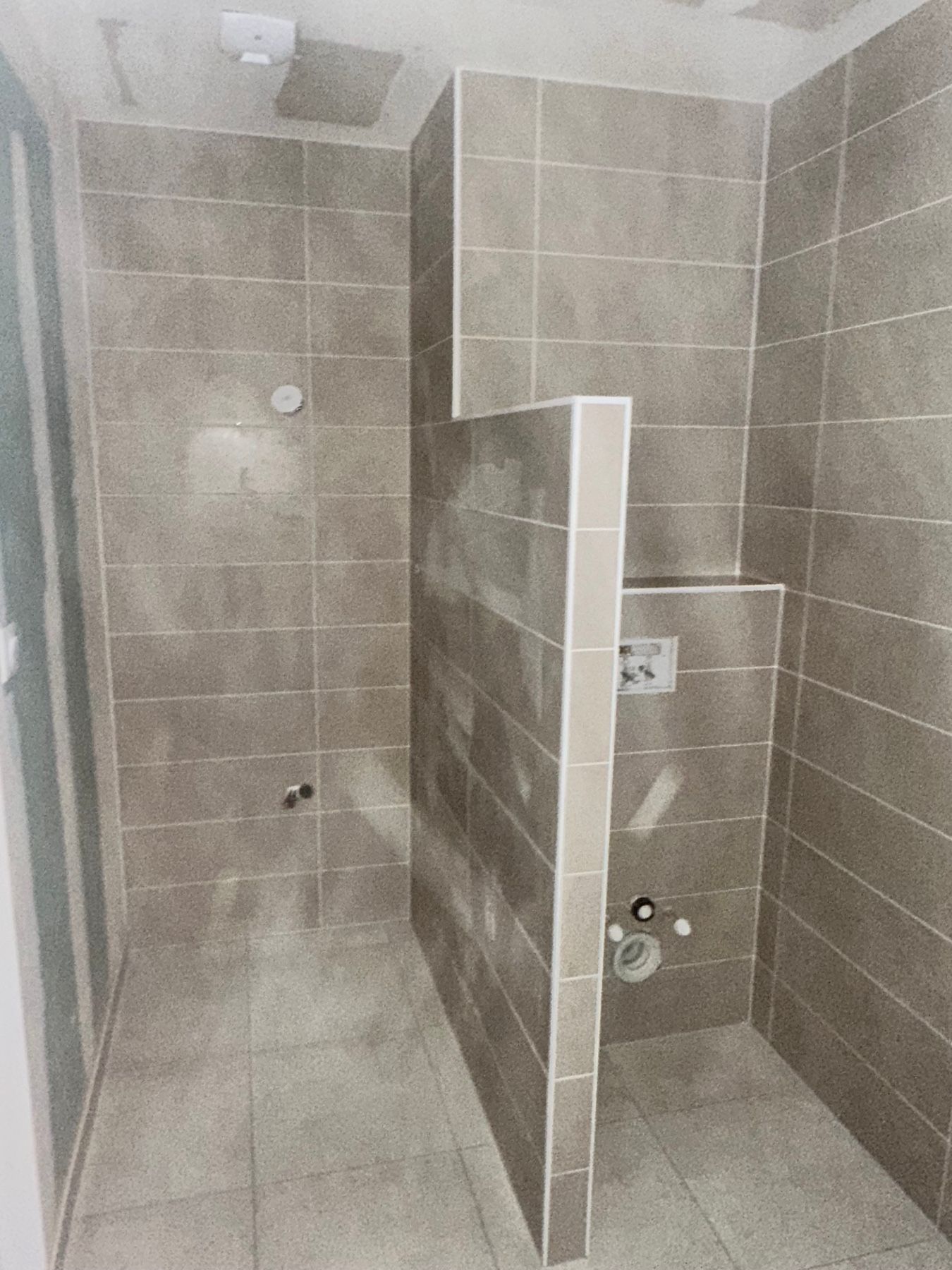 Une salle de bain avec des murs carrelés et des toilettes