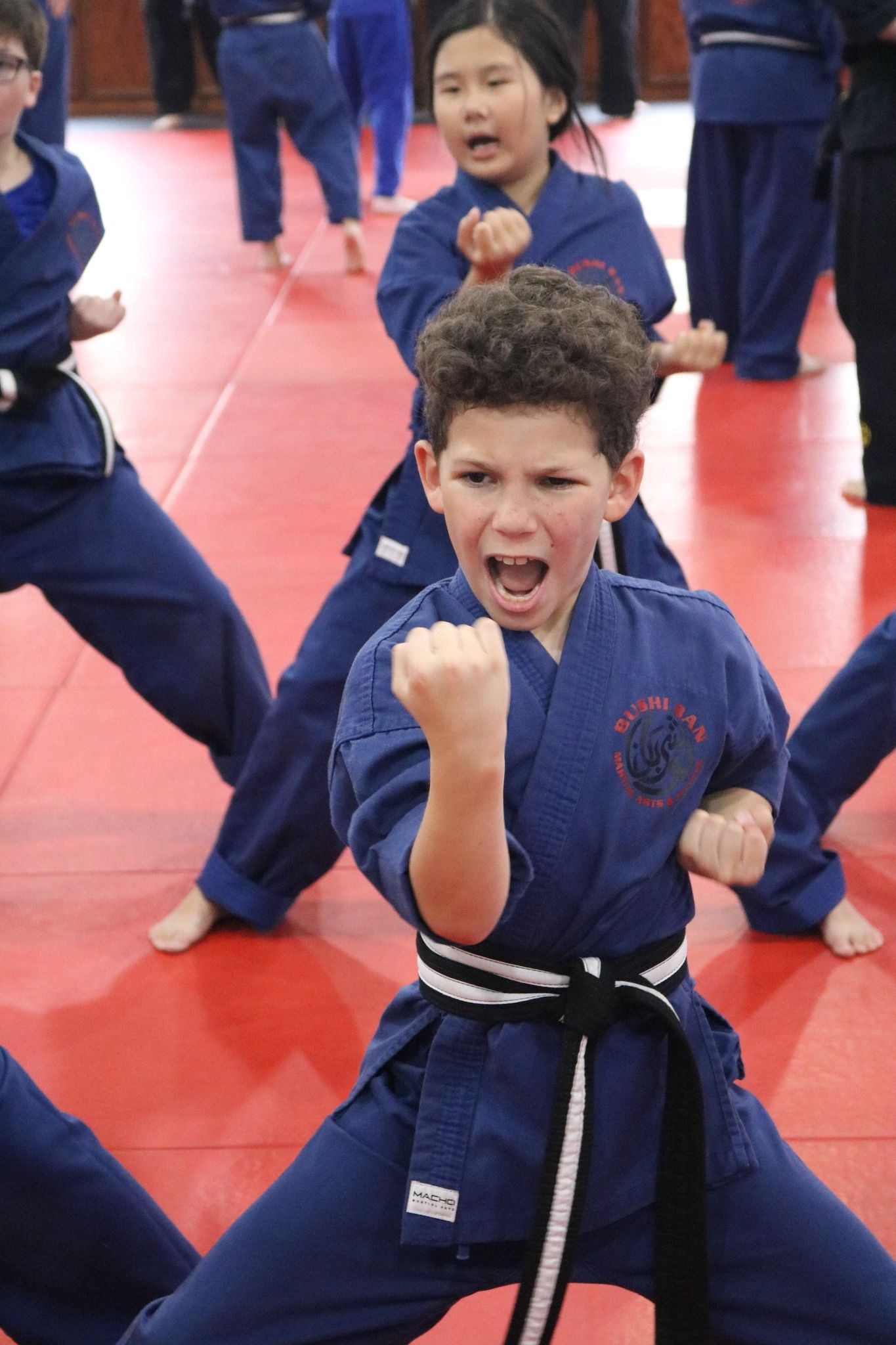 A boy in a blue karate uniform with a black belt