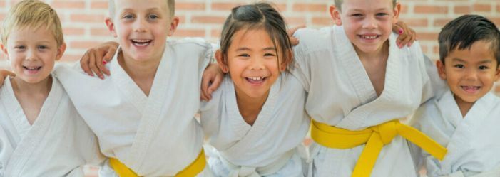 Karate kids standing joyfully together laughing