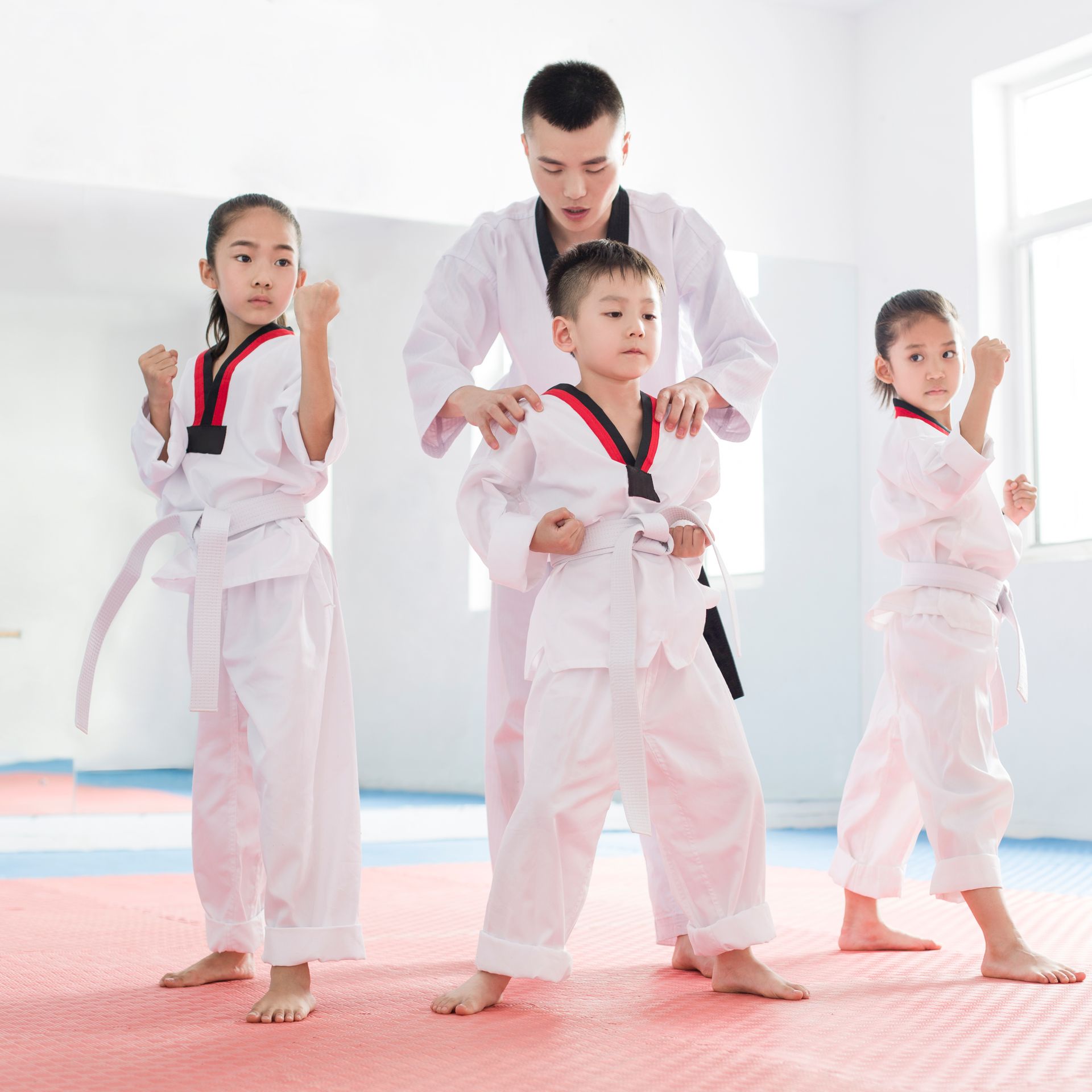 A group of children are practicing martial arts with a teacher.