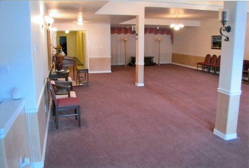An empty room with a purple carpet and chairs