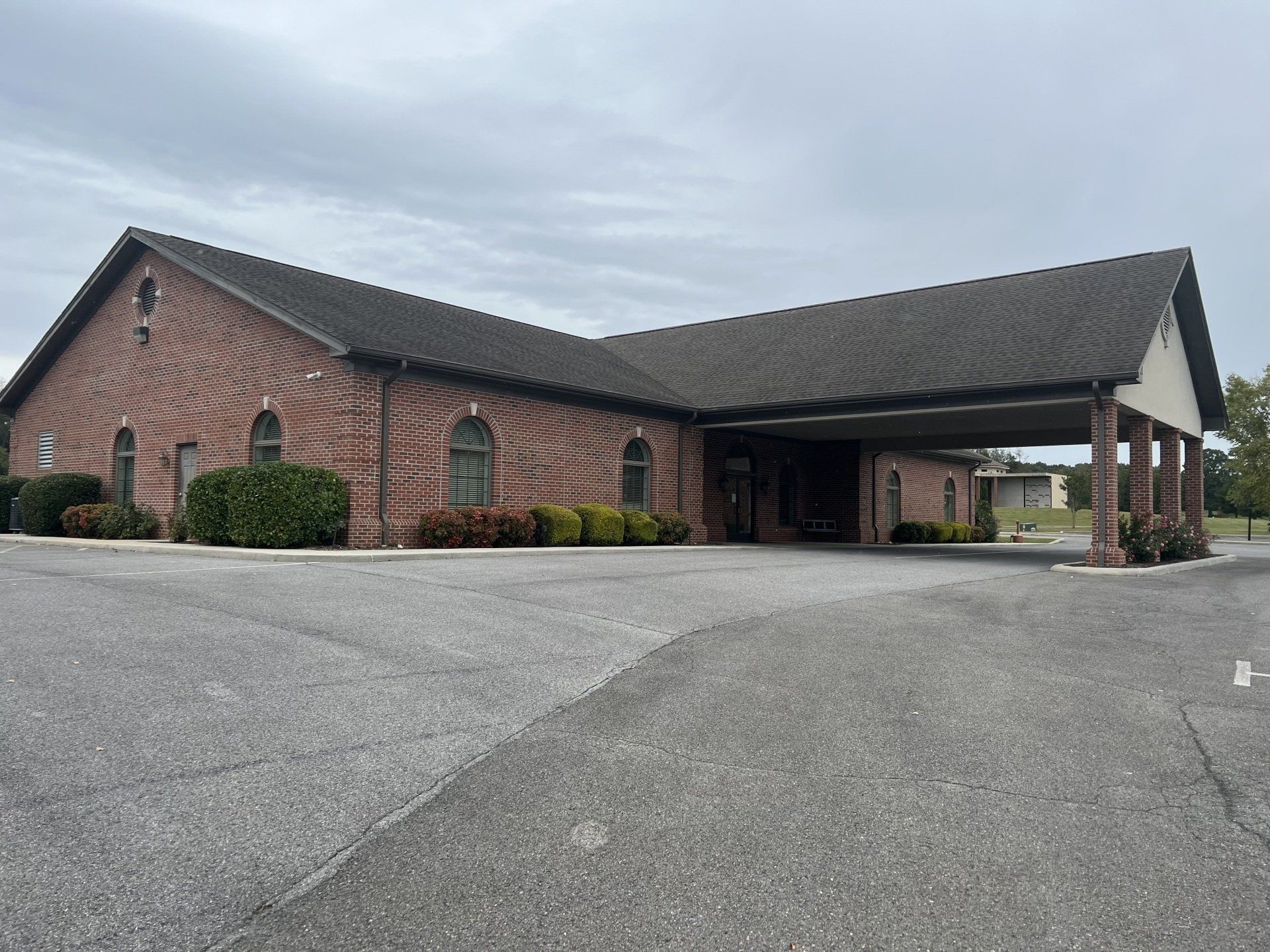 A large brick building with a parking lot in front of it.