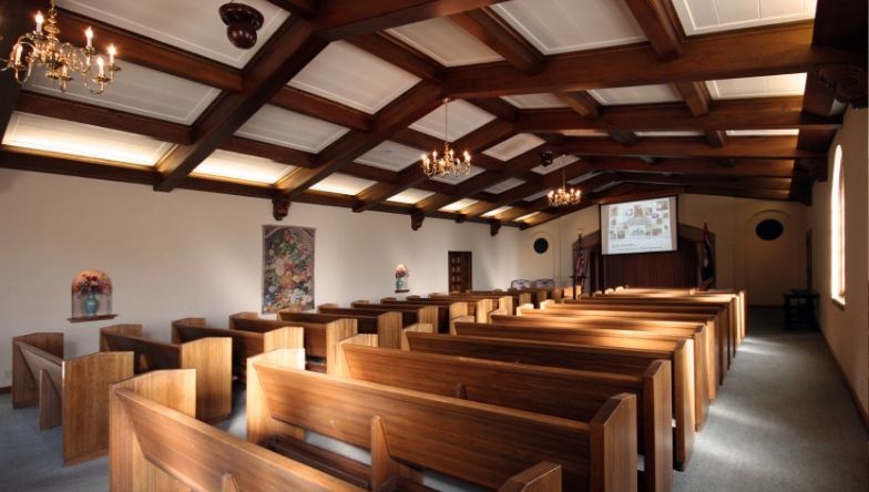 The inside of a church with rows of wooden benches