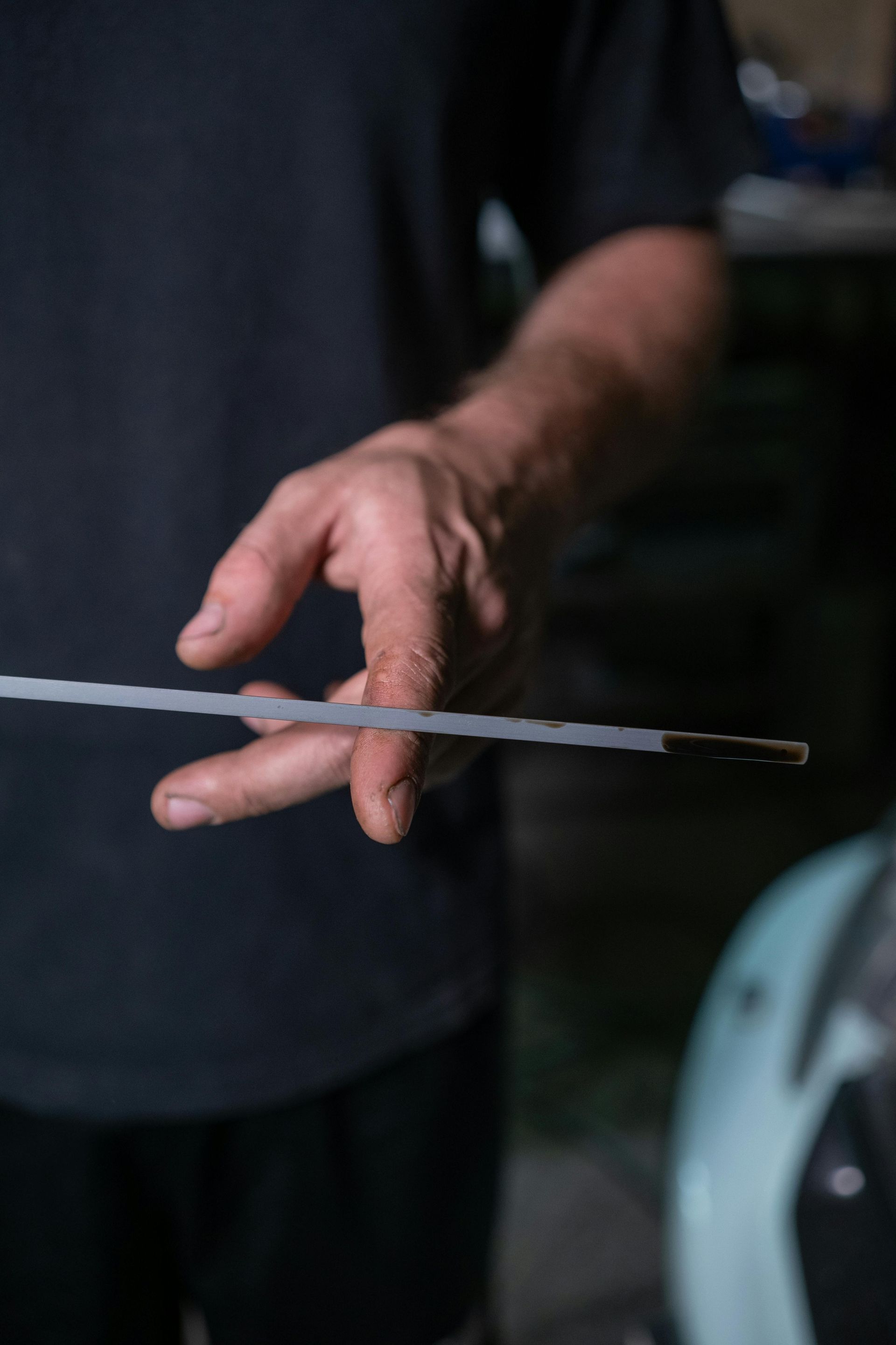 A close up of a person holding a thermometer in their hand.