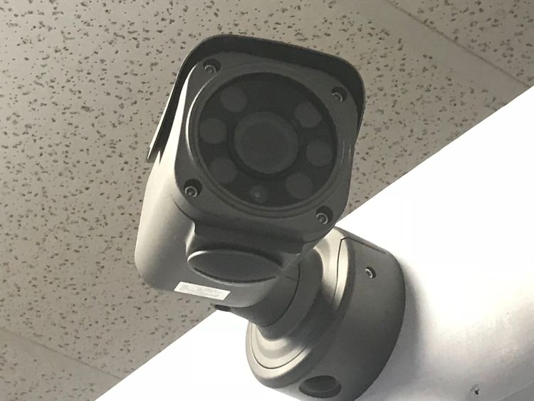 A security camera is mounted to a white wall