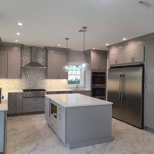 A kitchen with stainless steel appliances and gray cabinets