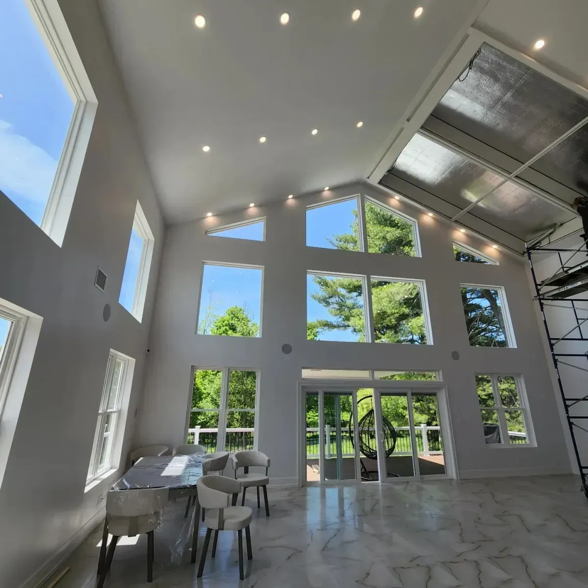 A large room with lots of windows and a table and chairs