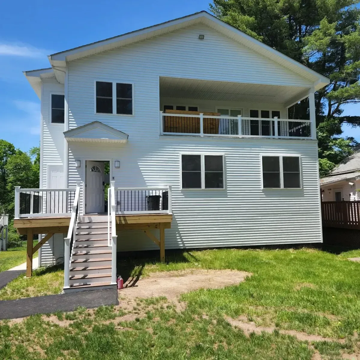 A white house with stairs leading up to the front door