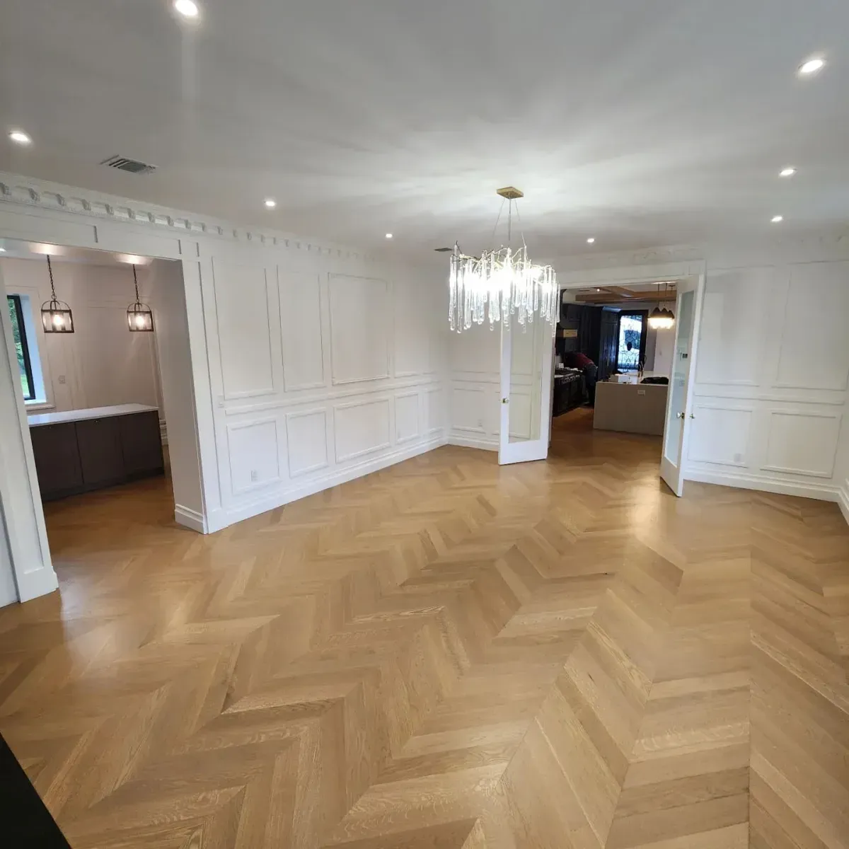 A large empty room with a wooden floor and white walls.