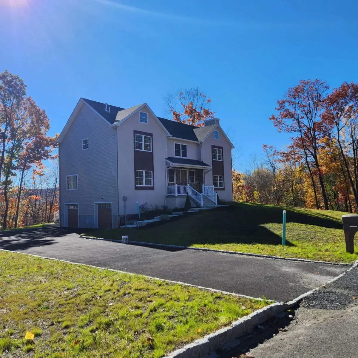 A large house sits on top of a lush green hillside