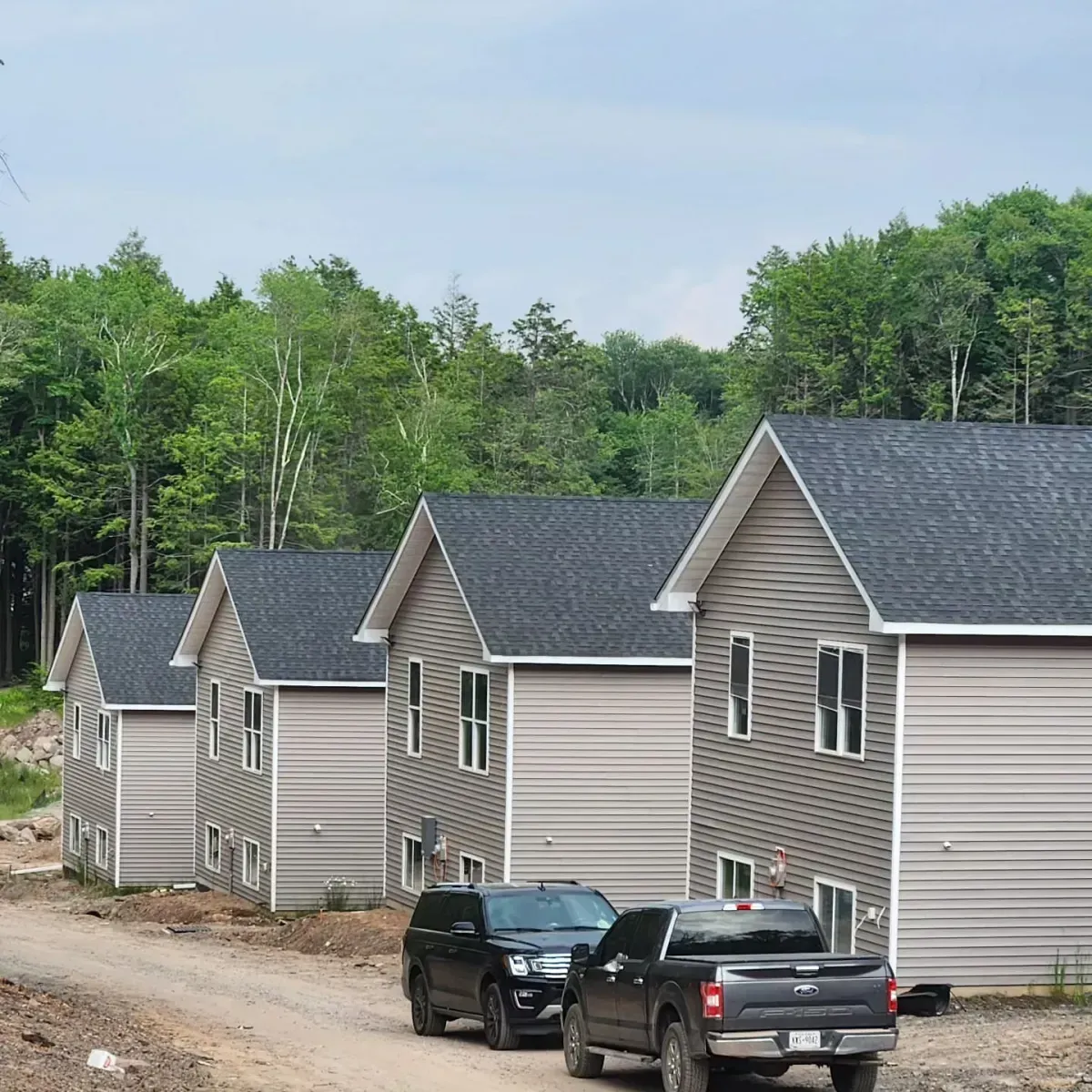 A black truck is parked in front of a row of houses