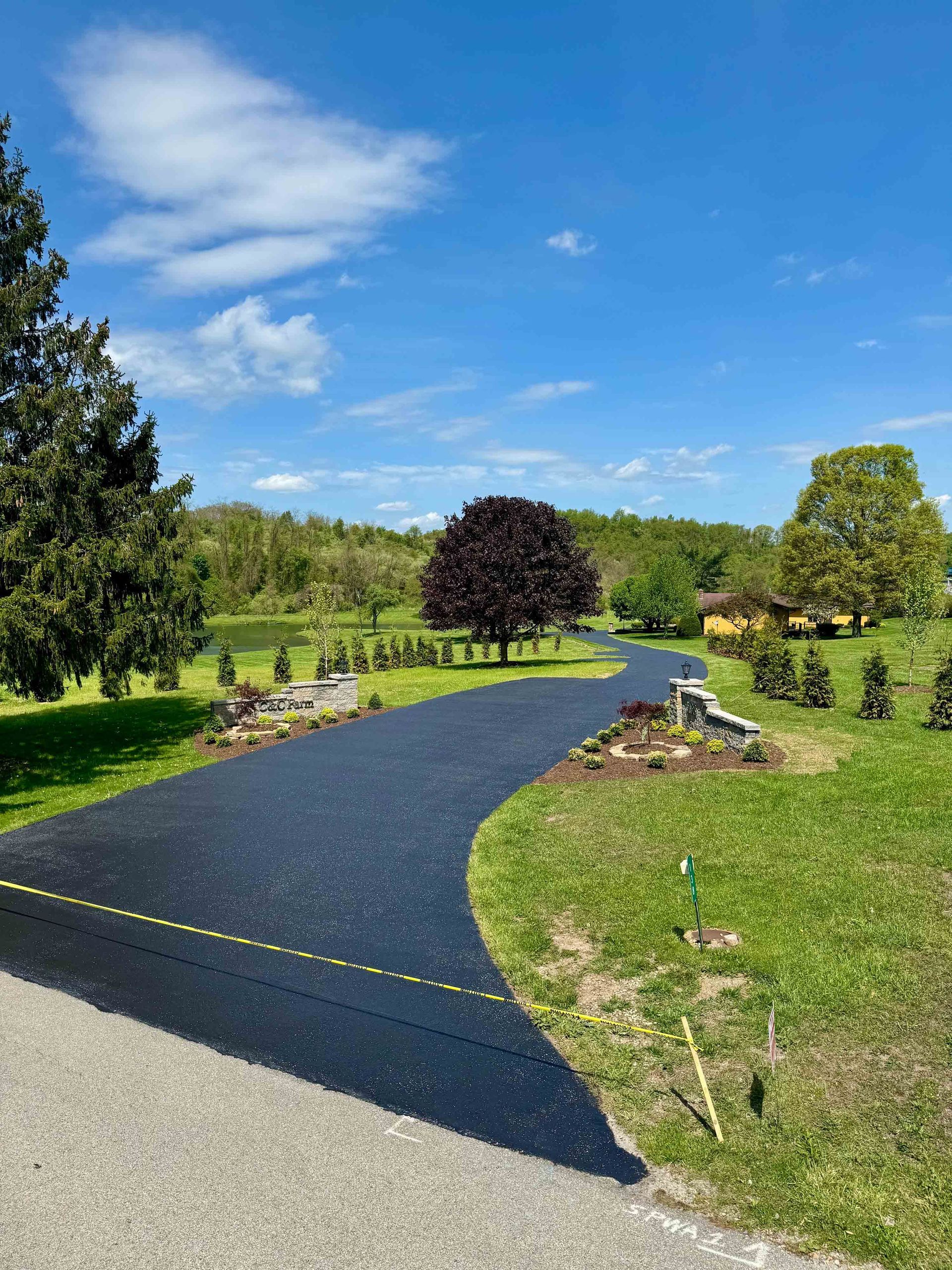 A man is painting a crosswalk with a sprayer.