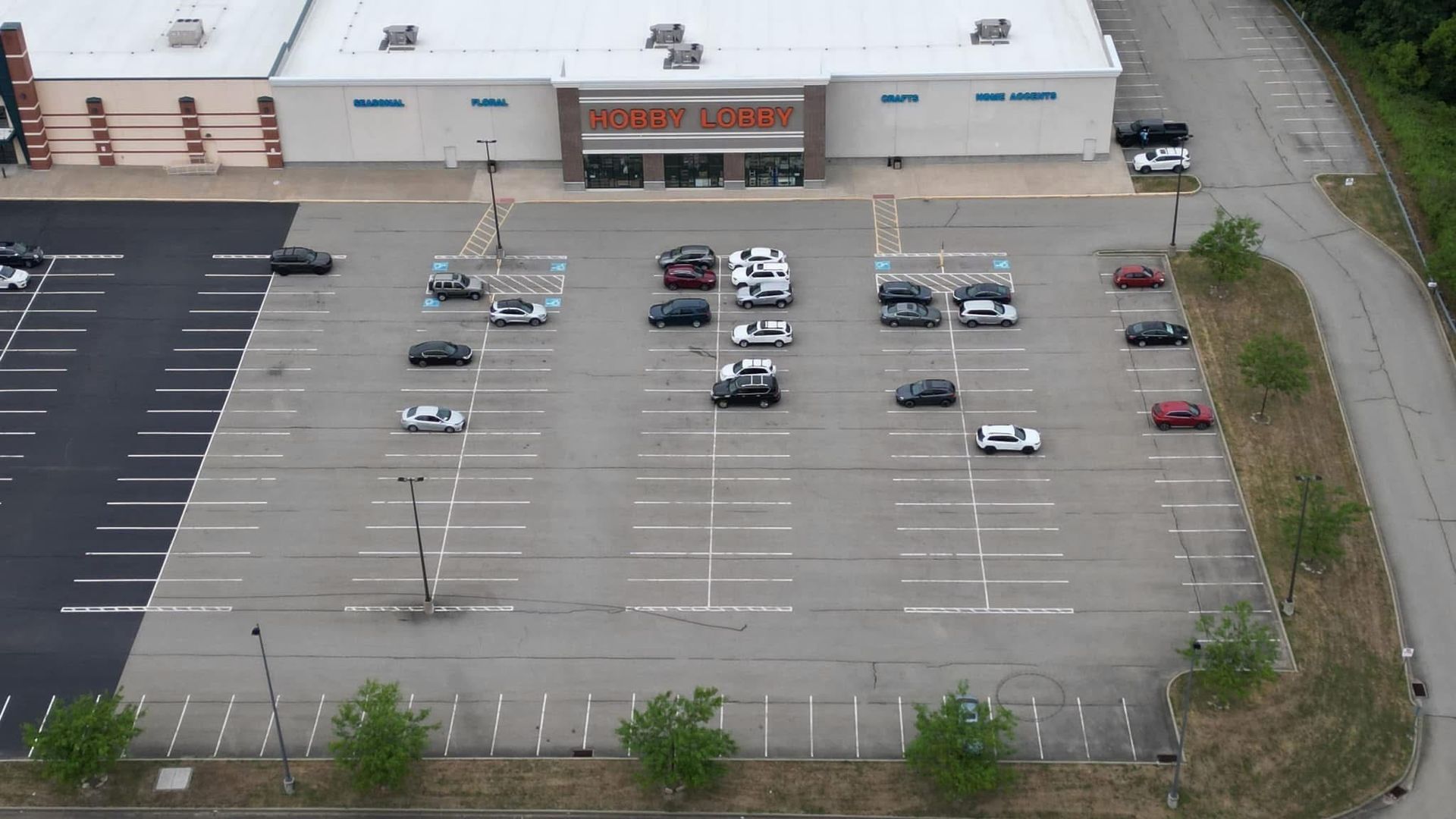 Before an aerial view of a parking lot in front of a store.