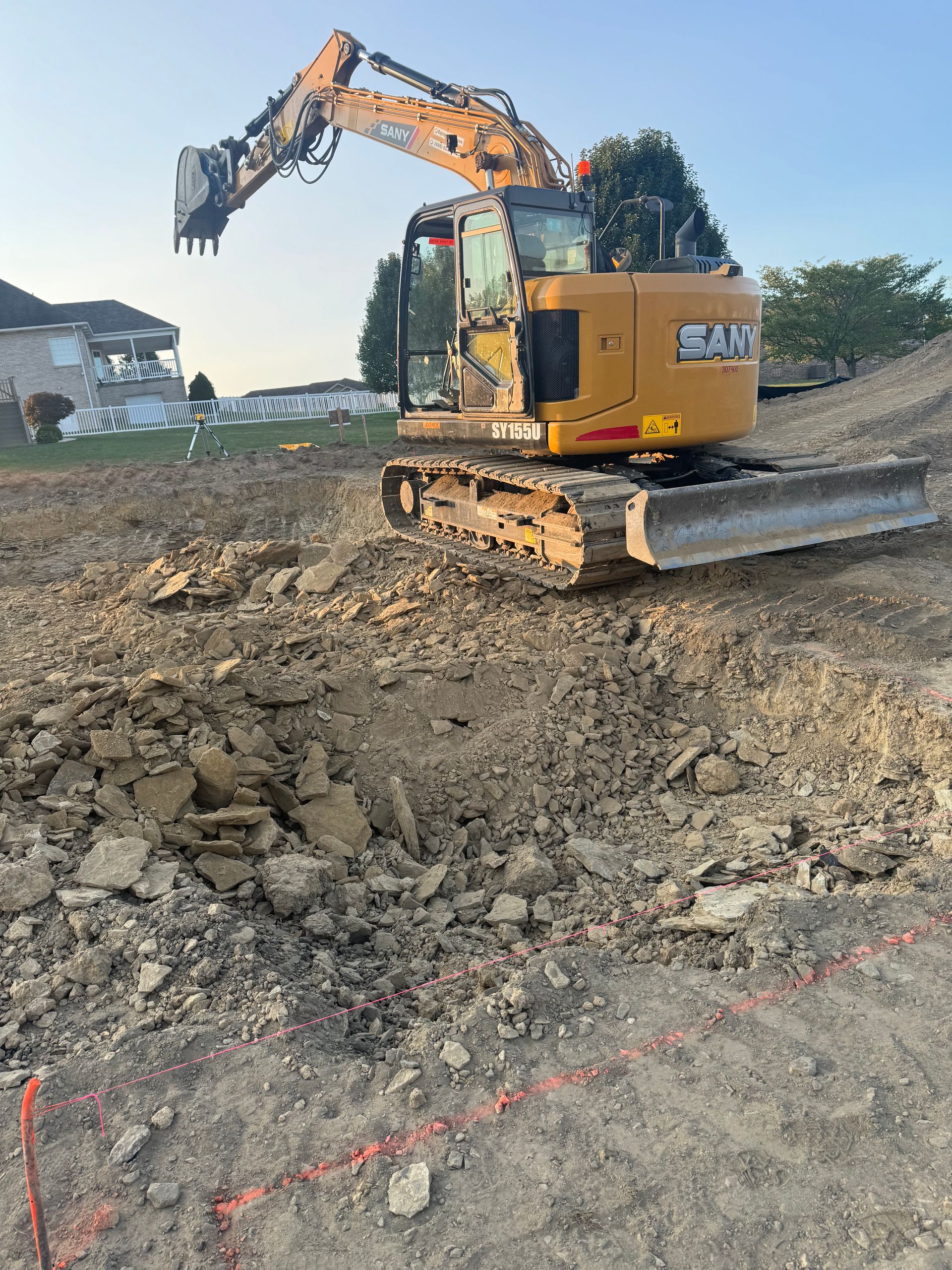 A yellow excavator is moving dirt on a construction site.