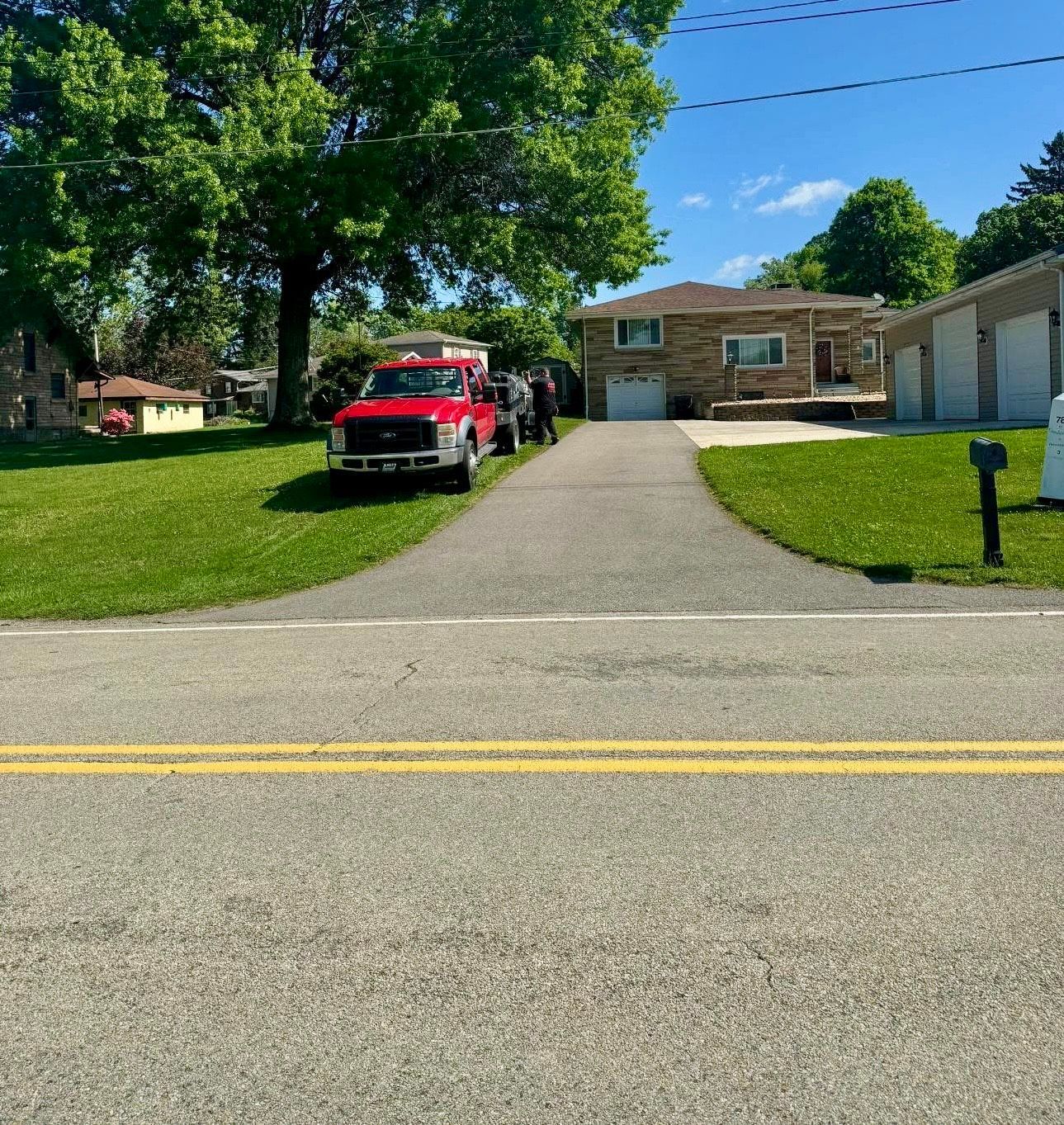 After a red truck is parked on the side of the road in front of a house.