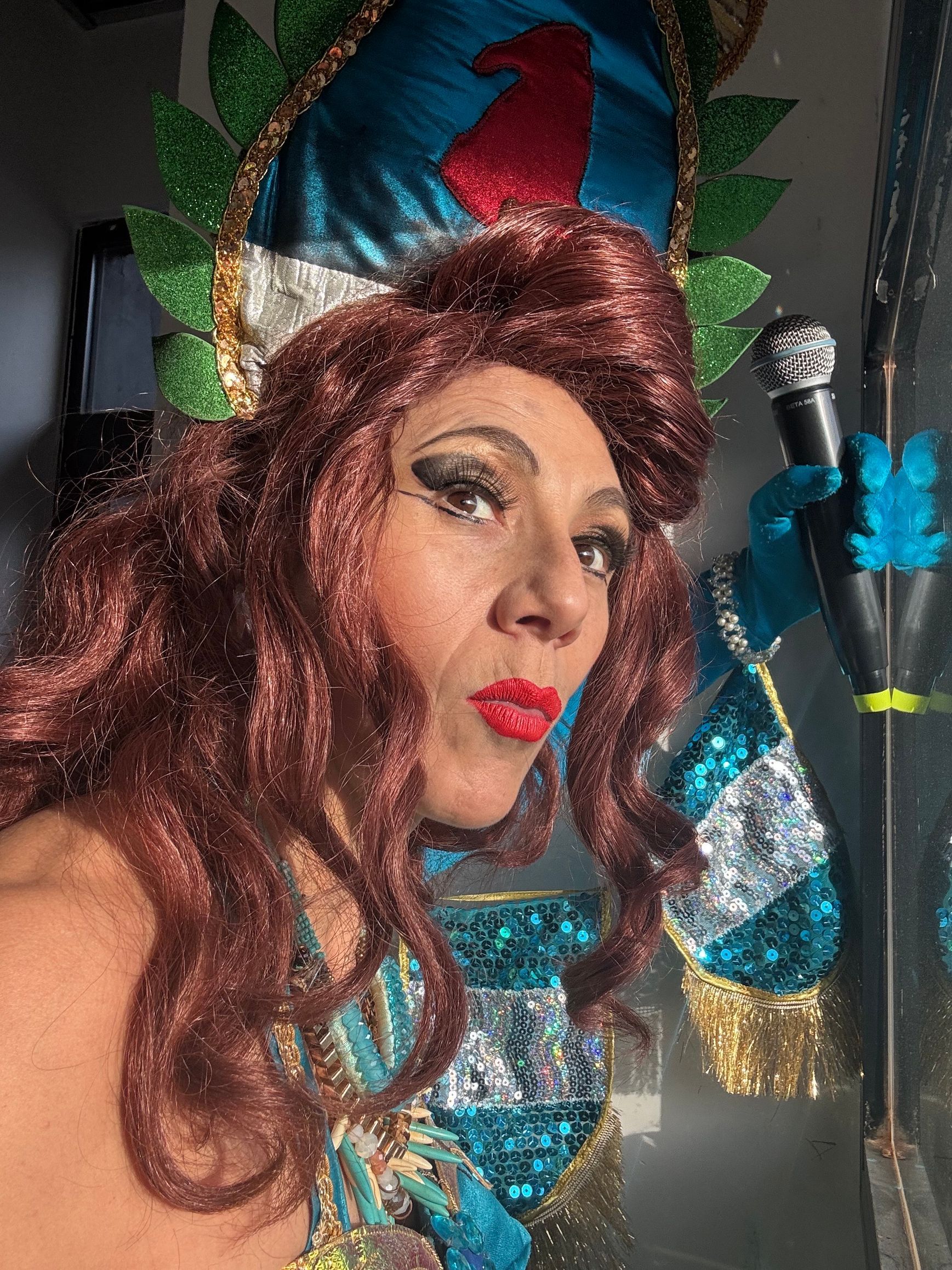 Una mujer disfrazada sostiene un micrófono.