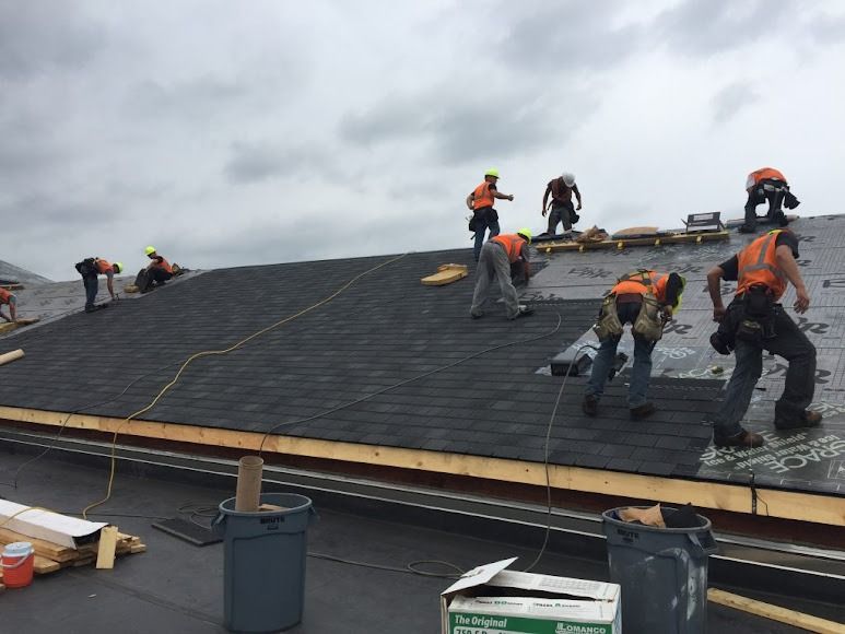 A group of construction workers are working on a roof.