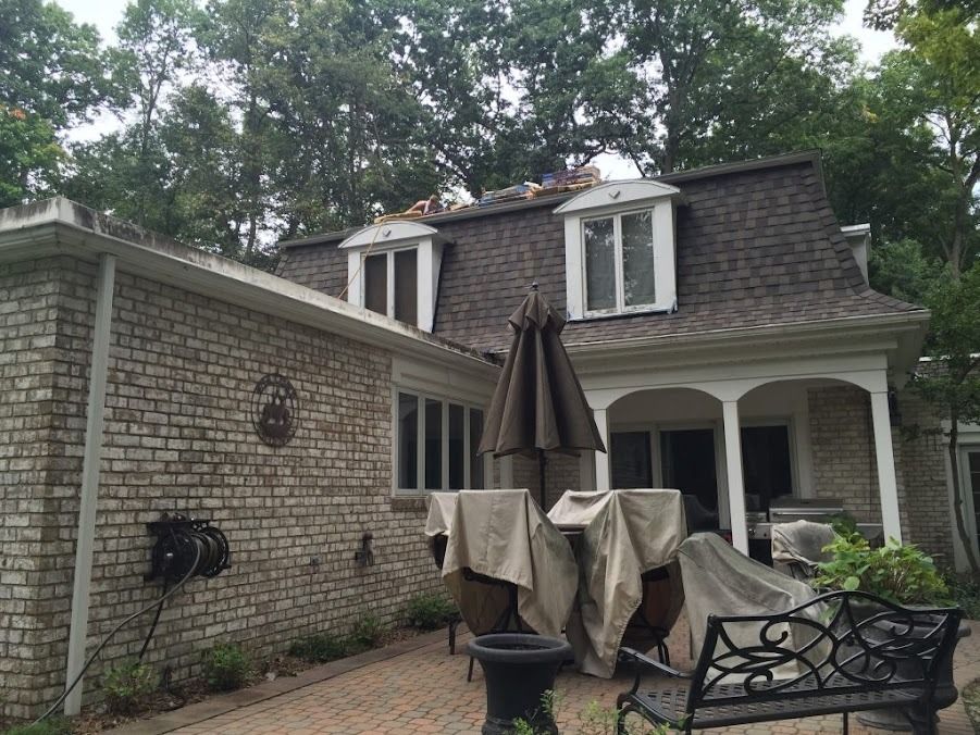 A brick house with a patio and umbrella in front of it