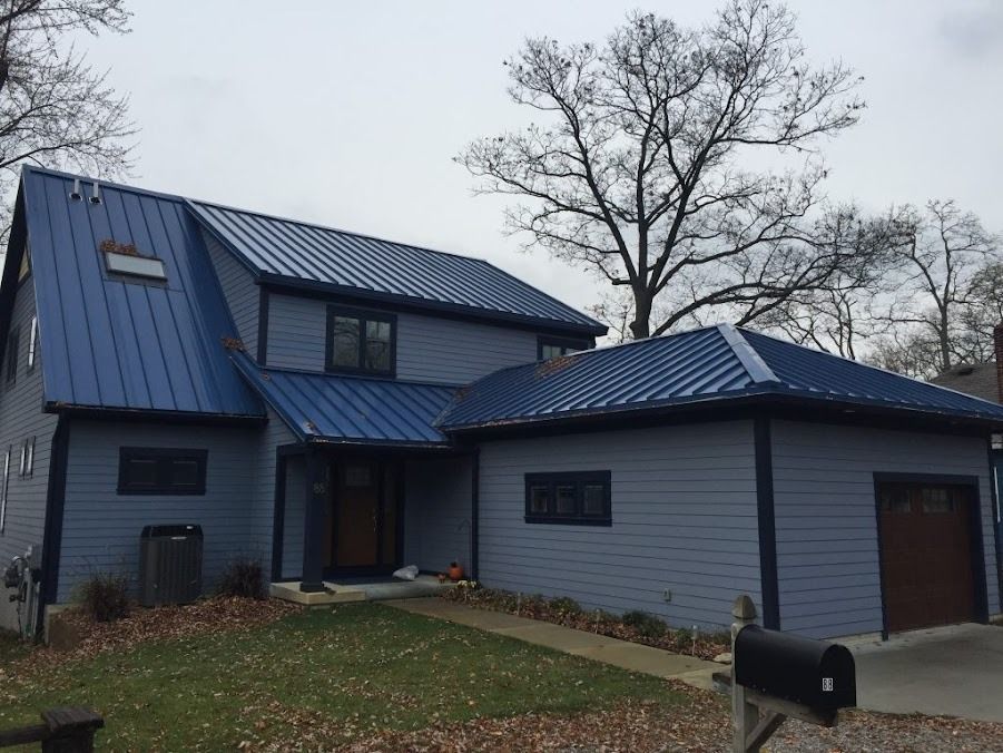 A blue house with a blue roof and a mailbox in front of it
