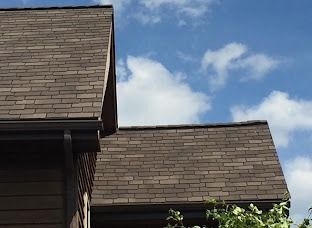 The roof of a house with a blue sky in the background.