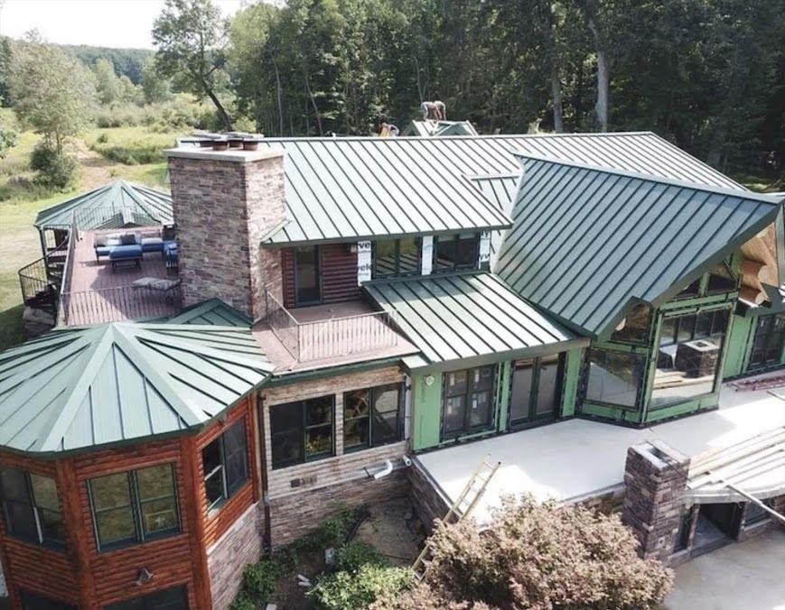 An aerial view of a large house with a green roof