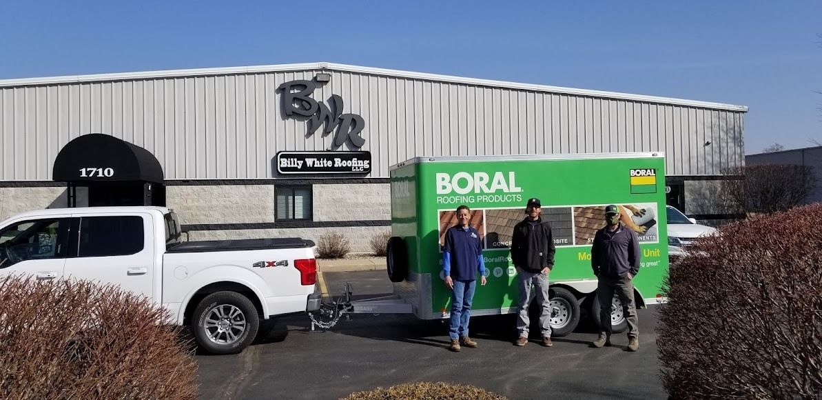 A group of people standing in front of a green food truck.