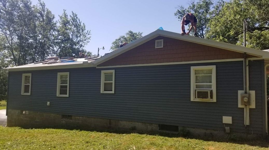 A man is working on the roof of a house.