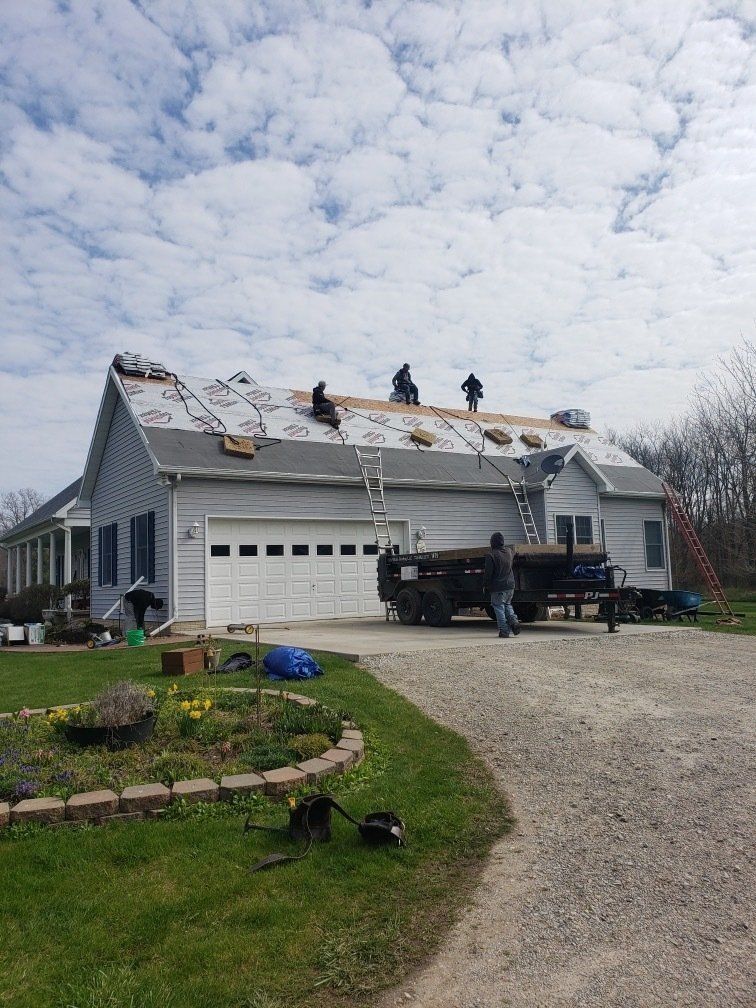 A group of people are working on the roof of a house.